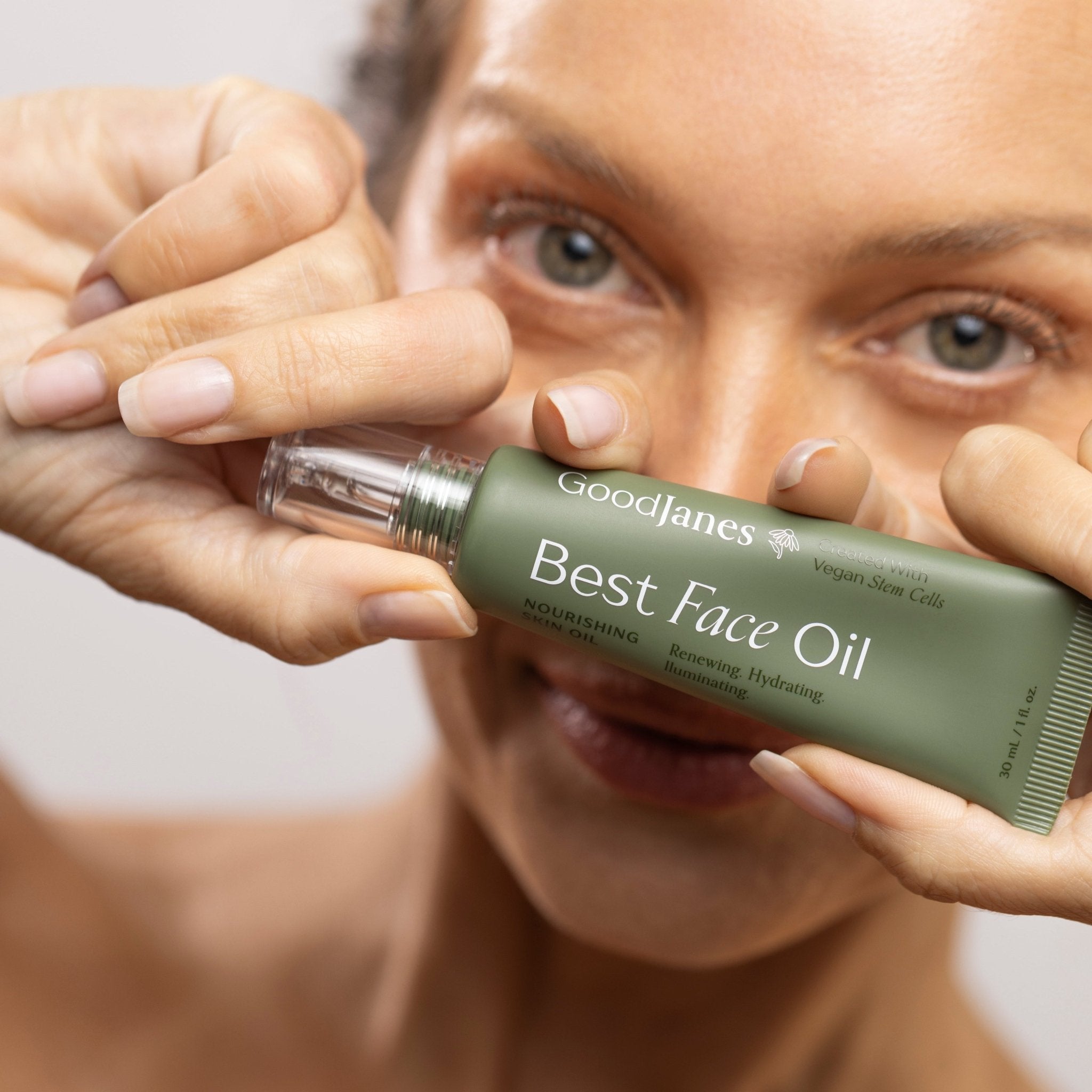 Person holding a tube of Goodlanes Best Face Oil close to their face.