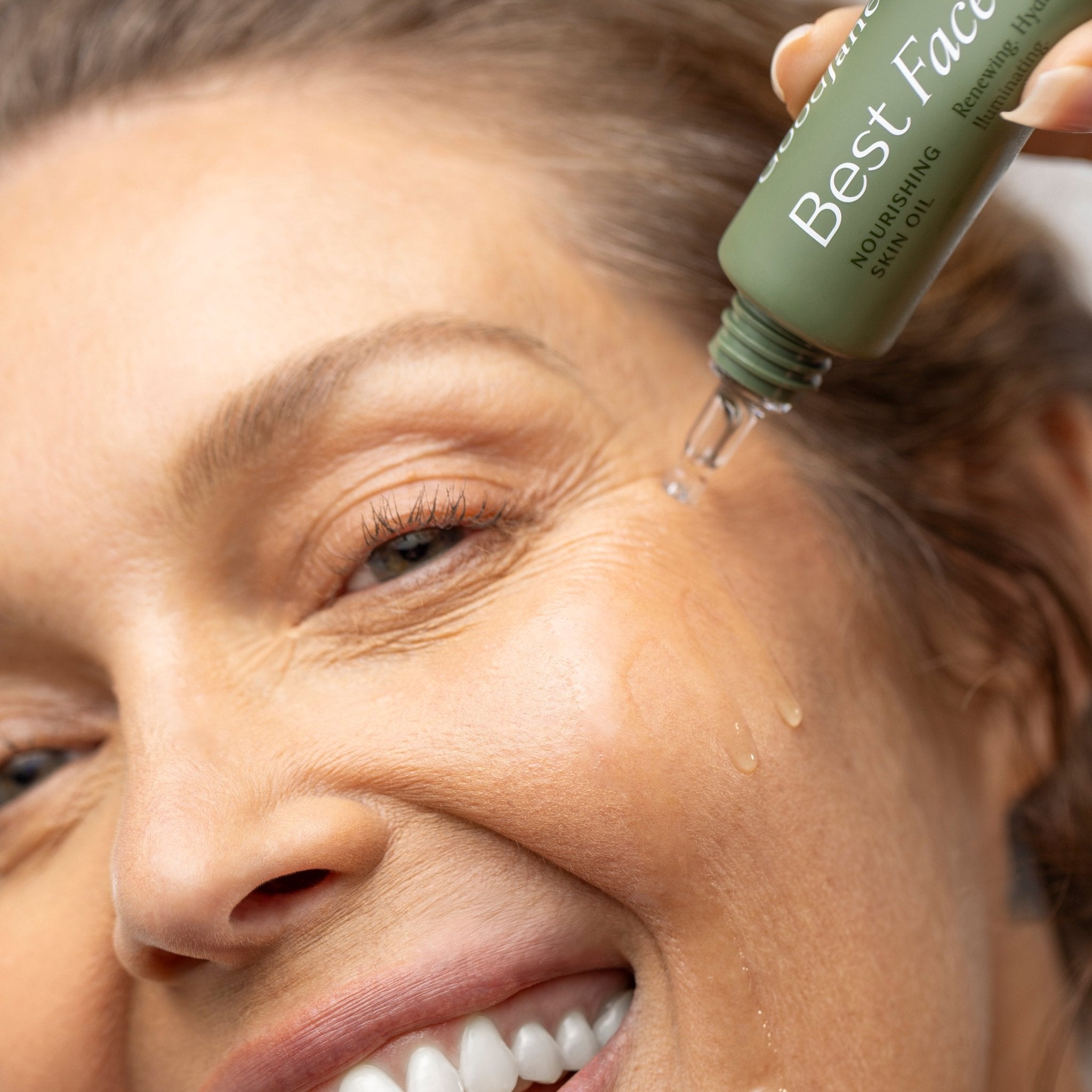 Woman applying a skincare product to her face with a dropper.