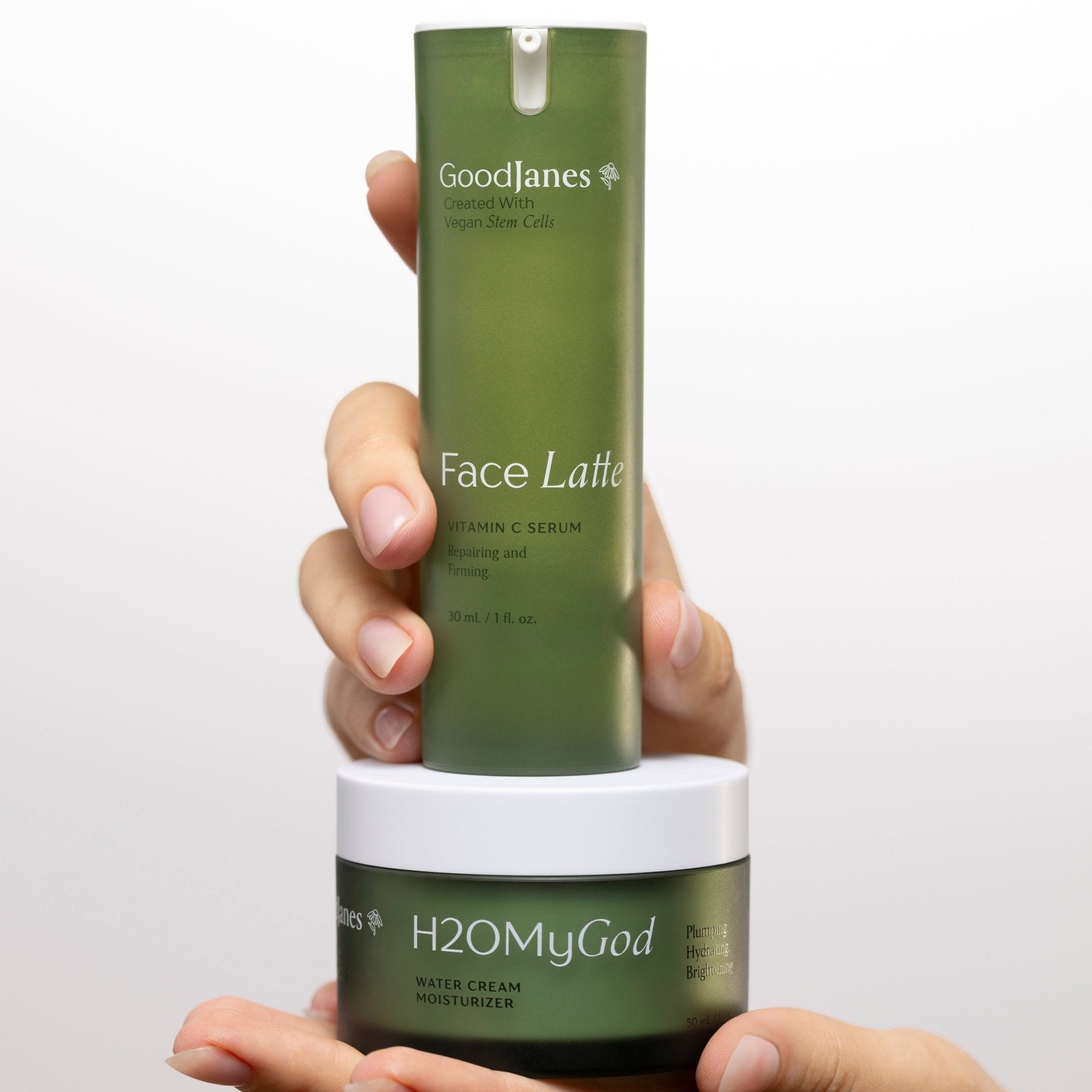 Hand holding two skincare products with 'Goodlanes' and 'H2O My God' branding against a white background.